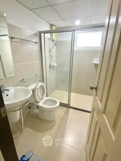 Modern bathroom with glass shower enclosure and sleek fixtures