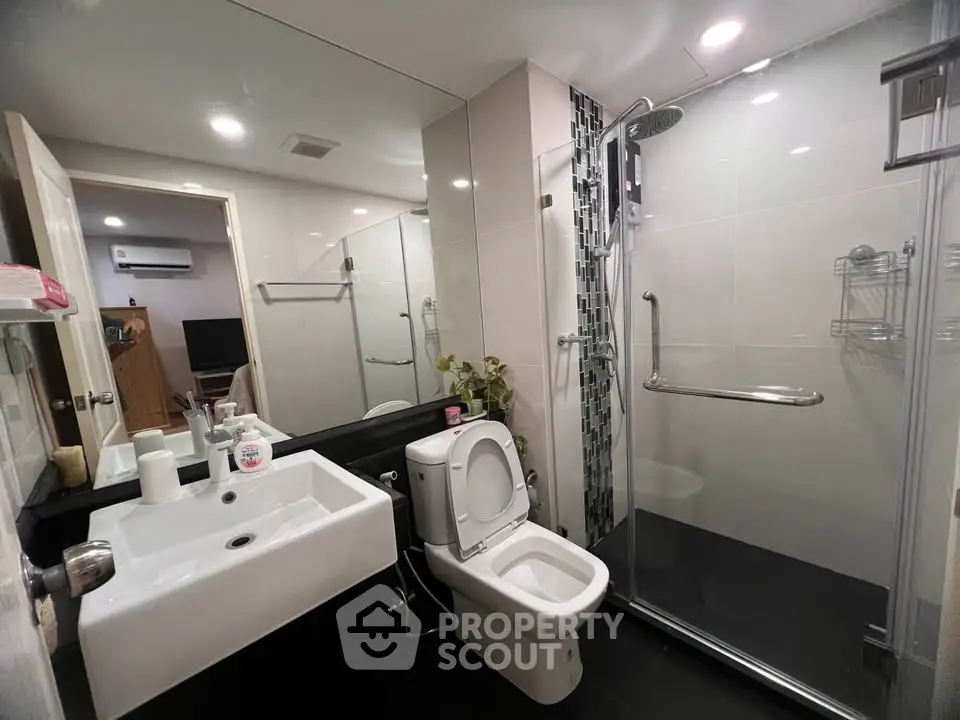 Modern bathroom with sleek design, glass shower, and contemporary fixtures in a stylish apartment.