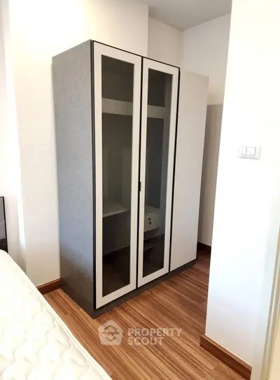 Modern bedroom with stylish wardrobe and wooden flooring