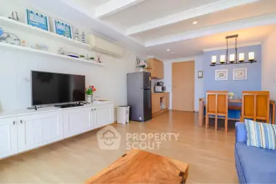 Spacious living room with modern decor and open dining area, featuring stylish furniture and ample natural light.