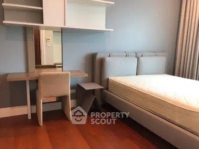 Modern bedroom with stylish furniture and hardwood floors, featuring a cozy bed and functional desk area.