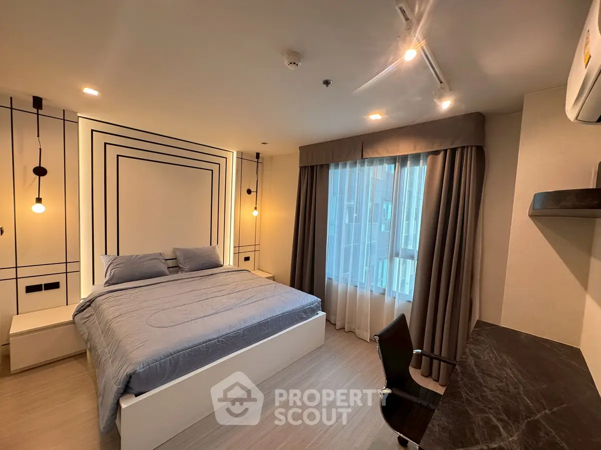 Modern bedroom with stylish decor, large bed, and natural light from window, perfect for urban living.