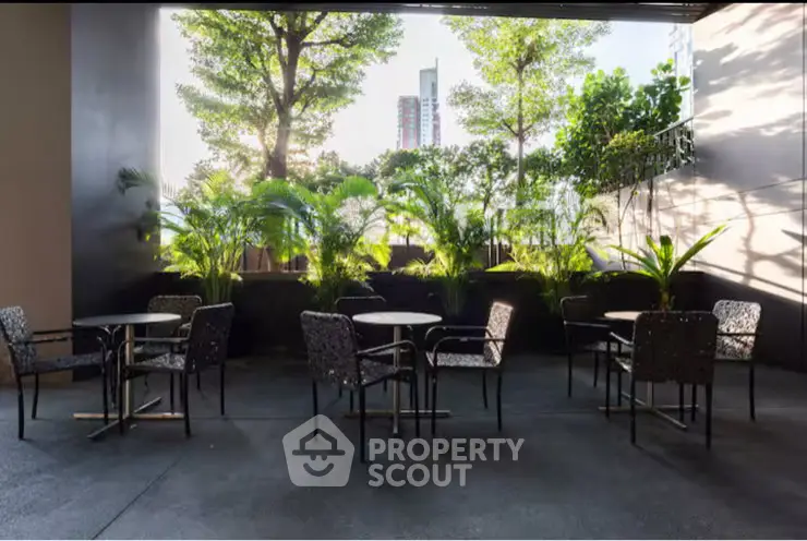 Chic outdoor seating area with lush greenery and city views, perfect for relaxation and social gatherings.