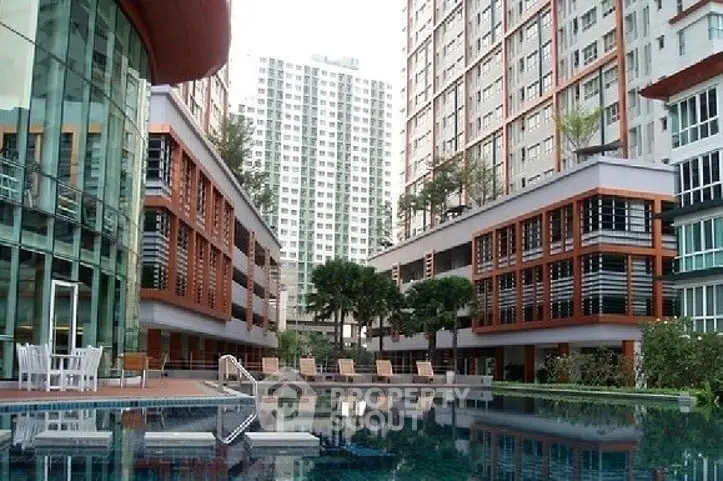 Luxurious condominium complex with modern architecture and inviting swimming pool.