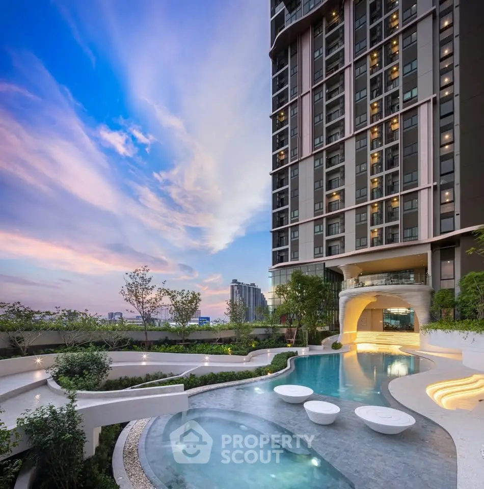 Luxurious high-rise building with stunning pool and garden view at sunset.