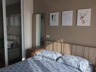 Cozy bedroom with stylish decor and natural light, featuring a comfortable bed and elegant wall art.