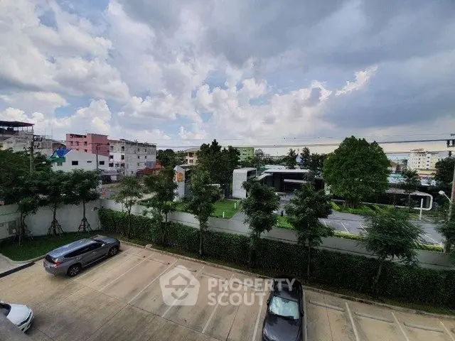 Scenic view from a residential building showcasing parking area and lush greenery.