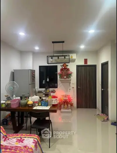 Modern kitchen with dining area featuring sleek design and contemporary lighting.