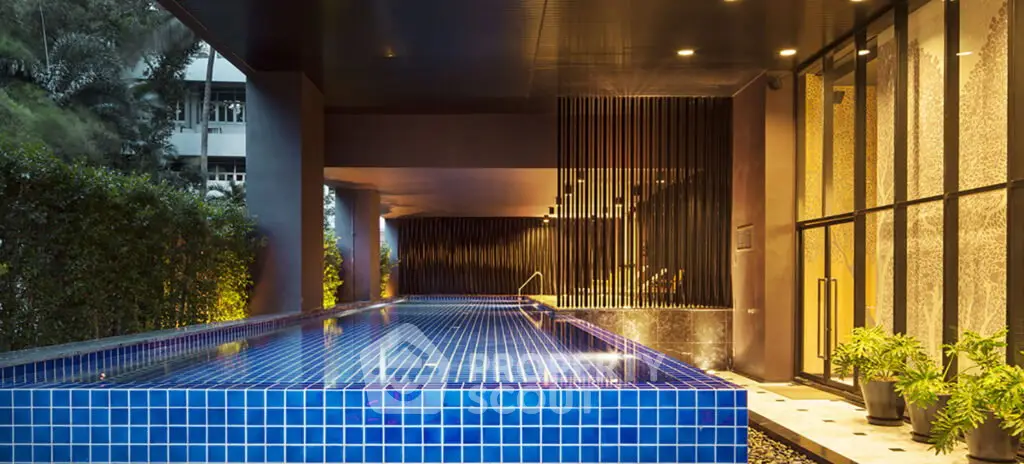 Luxurious modern building with stunning blue-tiled pool and elegant design.