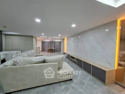 Spacious modern living room with elegant marble wall and plush seating
