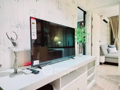 Modern living room with stylish decor, large flat-screen TV, and cozy seating area leading to a sunny balcony, perfect for entertaining.