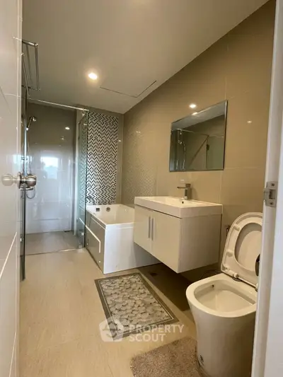 Modern bathroom with sleek fixtures and a glass-enclosed shower, featuring a stylish bathtub and elegant vanity.