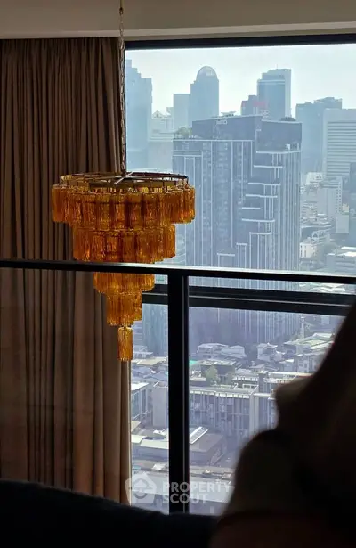 Luxurious high-rise apartment with stunning city view and elegant chandelier.