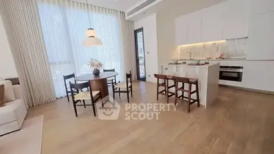 Spacious modern kitchen with open layout and dining area, featuring elegant wooden flooring and natural light.