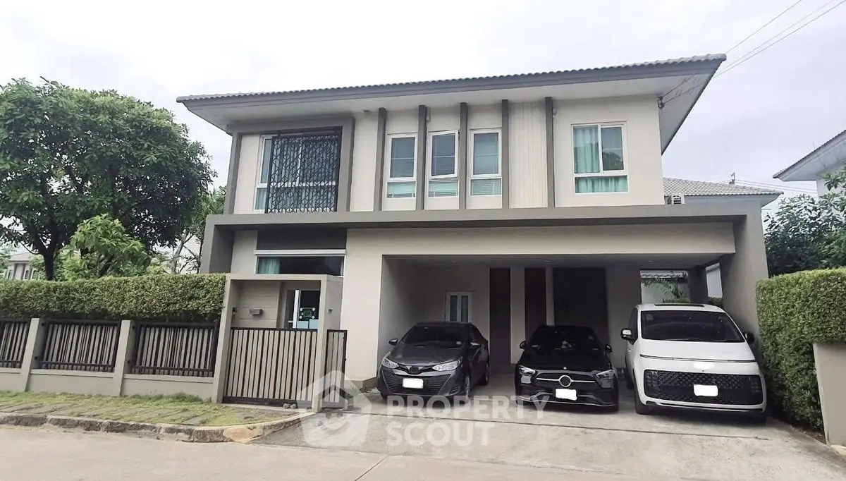 Modern two-story house with spacious driveway and three parked cars in a serene neighborhood.