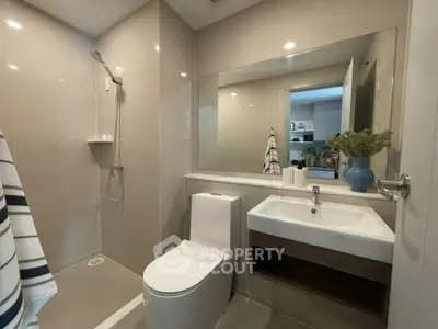 Modern bathroom with sleek fixtures and large mirror in contemporary apartment.