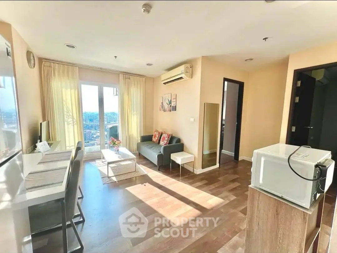 Bright and airy living room with modern decor and city view, featuring hardwood floors and cozy seating area.