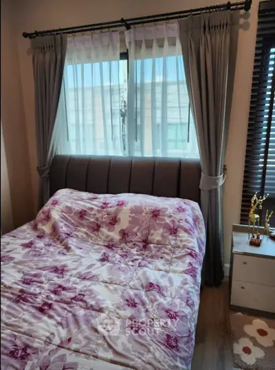 Cozy bedroom with floral bedding and elegant curtains