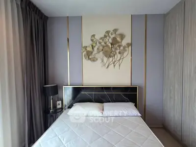 Modern bedroom with stylish decor and elegant wall art, featuring a comfortable bed and sleek furnishings.