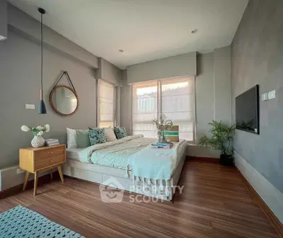 Modern bedroom with stylish decor and large windows offering natural light.