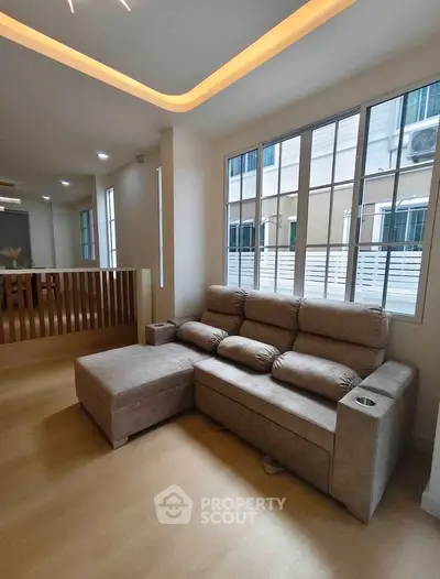 Spacious living room with modern sofa and large windows in a stylish apartment.