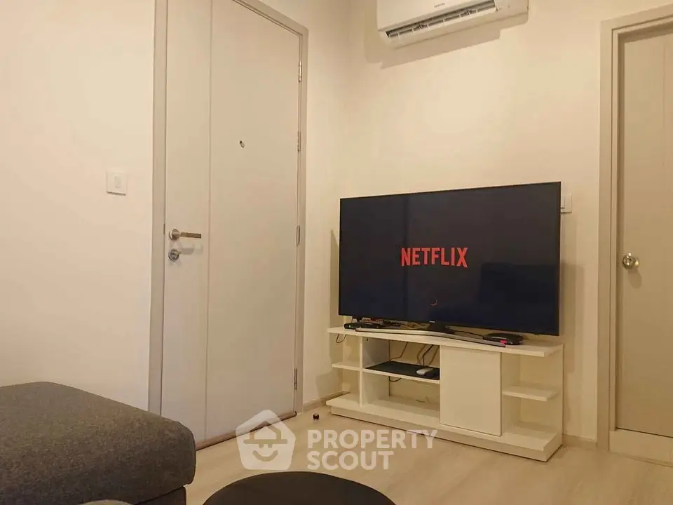 Cozy living room with modern TV setup and air conditioning.