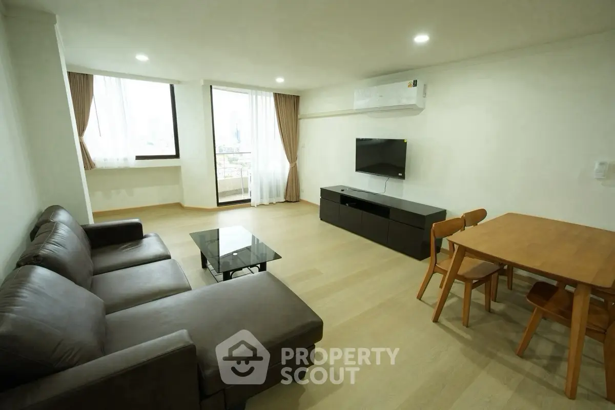 Spacious living room with modern furniture and city view, perfect for relaxation and entertainment.