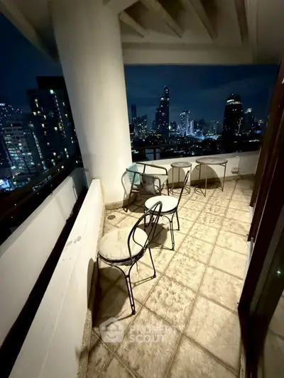 Stunning city view from spacious balcony at night, perfect for relaxation.