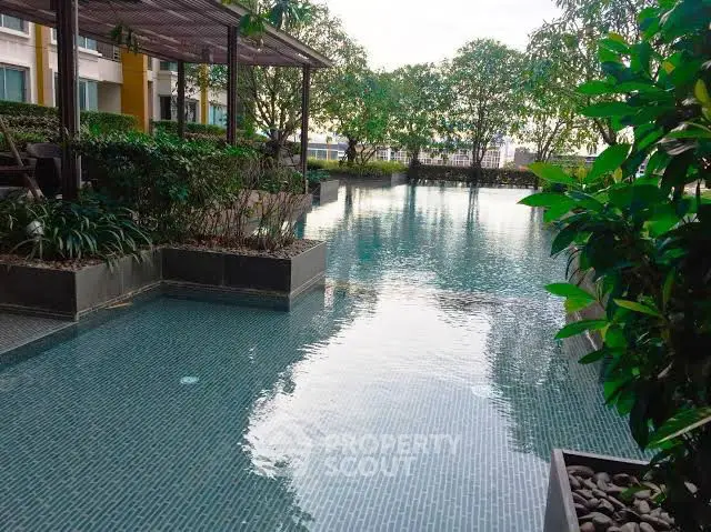Luxurious residential pool surrounded by lush greenery, perfect for relaxation and leisure.