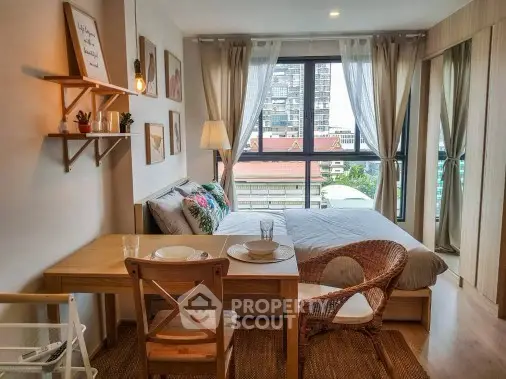 Cozy bedroom with dining area and large window offering city view