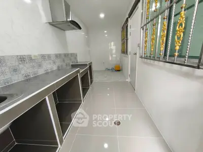 Modern kitchen with sleek tile flooring and stainless steel countertops
