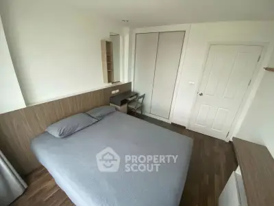 Modern bedroom with sleek design, featuring a cozy bed, built-in wardrobe, and stylish wooden flooring.