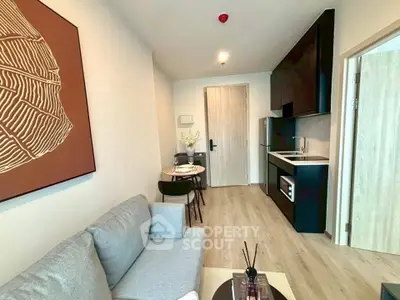 Modern living room with cozy sofa and stylish kitchen in open layout apartment.