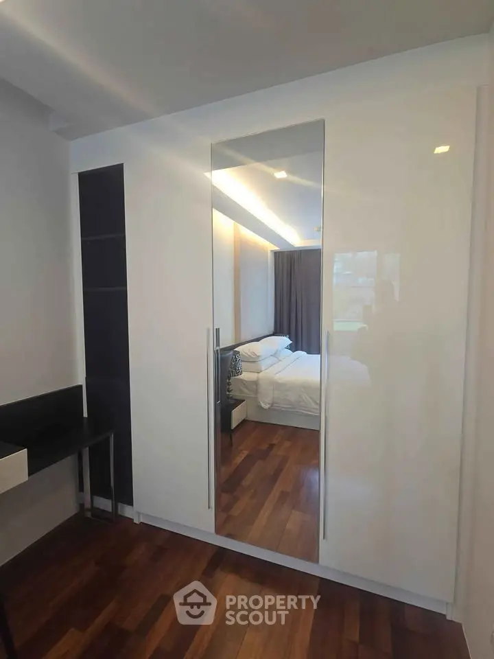 Modern bedroom with sleek wardrobe and wooden flooring