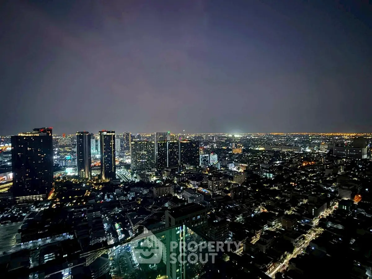 Stunning cityscape view from a high-rise building at night, showcasing vibrant urban lights.