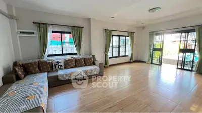 Spacious living room with large windows and cozy seating area, perfect for family gatherings.
