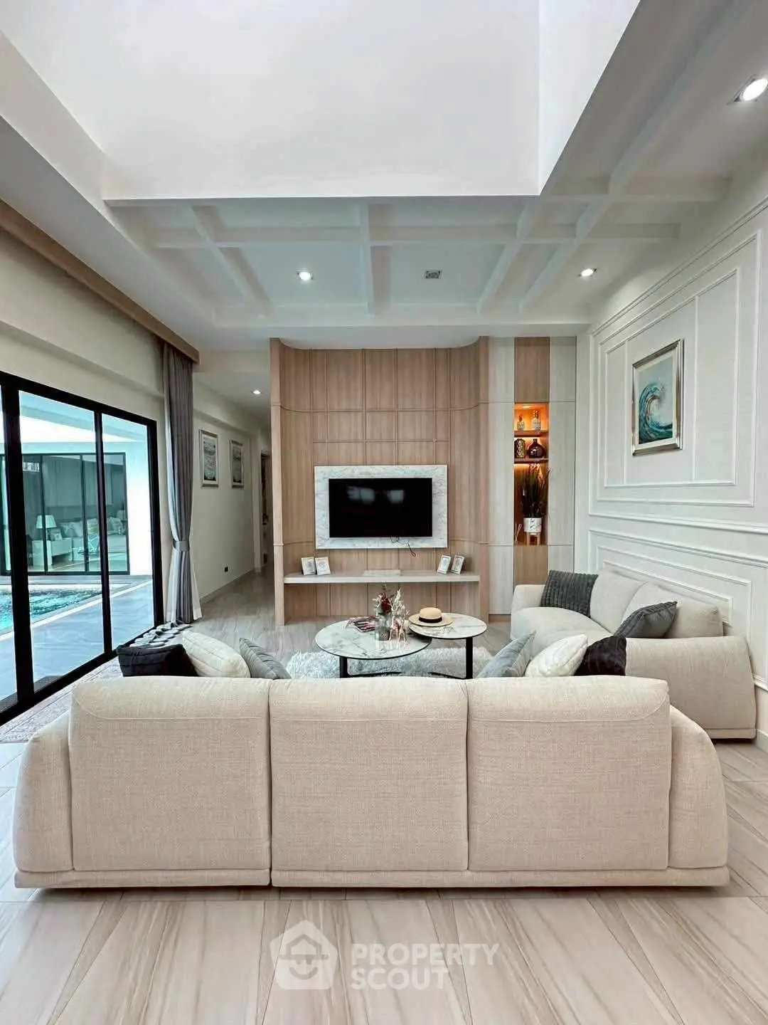 Luxurious modern living room with elegant decor and poolside view, perfect for relaxation and entertainment.