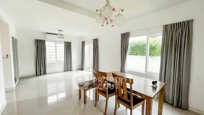 Spacious and bright living room with elegant dining area and large windows.