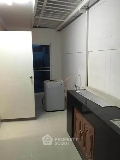 Spacious utility room with washing machine and storage cabinets