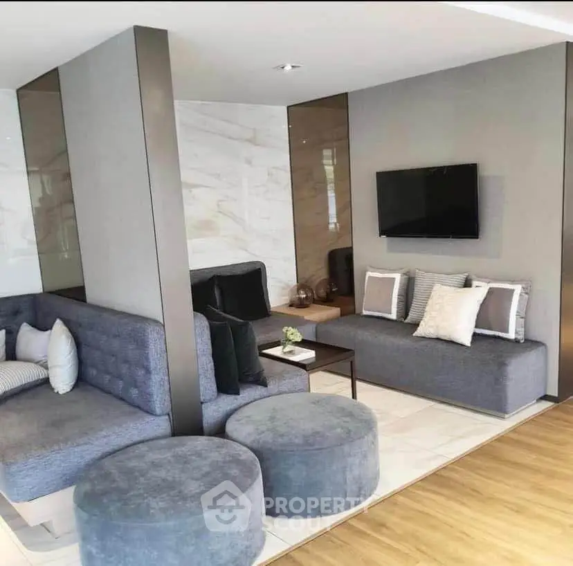 Modern living room with stylish gray furniture and wall-mounted TV, perfect for relaxation.