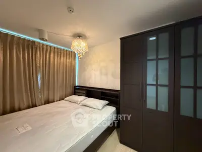 Cozy bedroom with elegant chandelier and spacious wardrobe in modern apartment.