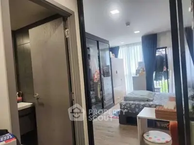 Cozy bedroom with modern decor and ample natural light, featuring a small adjacent bathroom.