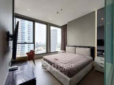Luxurious bedroom with panoramic city views and modern furnishings in high-rise apartment.