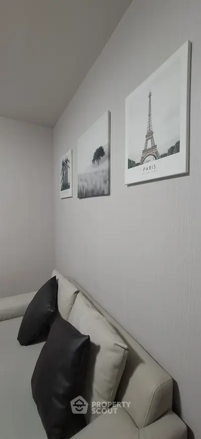 Modern living room with stylish decor and comfortable seating, featuring elegant wall art.