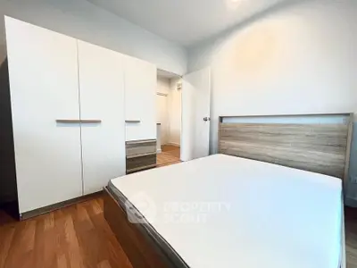 Spacious modern bedroom with sleek wooden furniture and ample storage space.