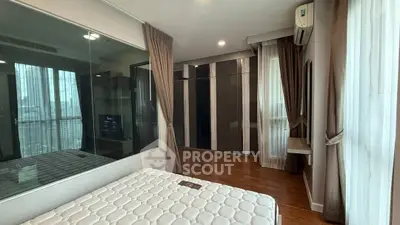 Modern bedroom with large window, wooden flooring, and built-in wardrobe in high-rise apartment.