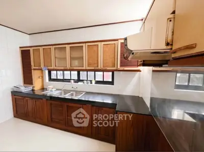 Spacious kitchen with wooden cabinets and sleek countertops in modern home.
