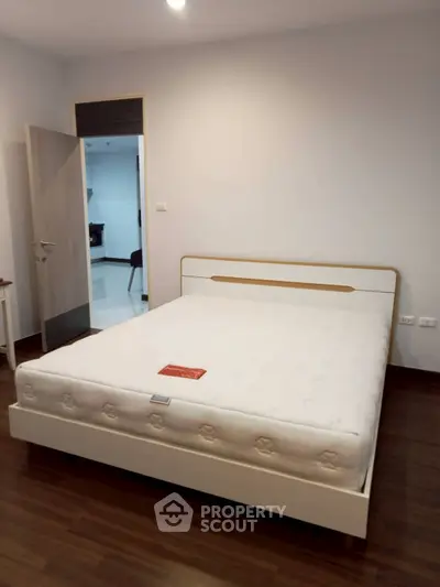 Modern bedroom with stylish bed and wooden flooring in a cozy apartment.