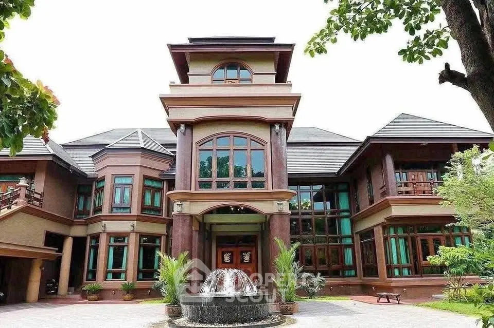 Luxurious mansion with grand entrance and elegant fountain in lush garden setting.