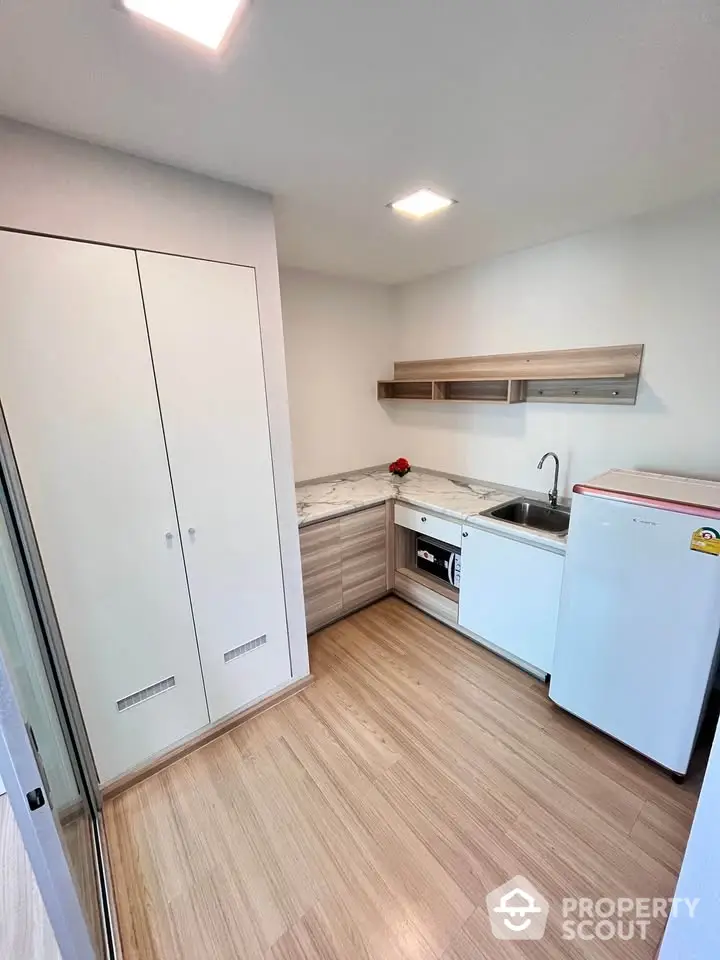 Modern compact kitchen with sleek cabinets and appliances in a stylish apartment